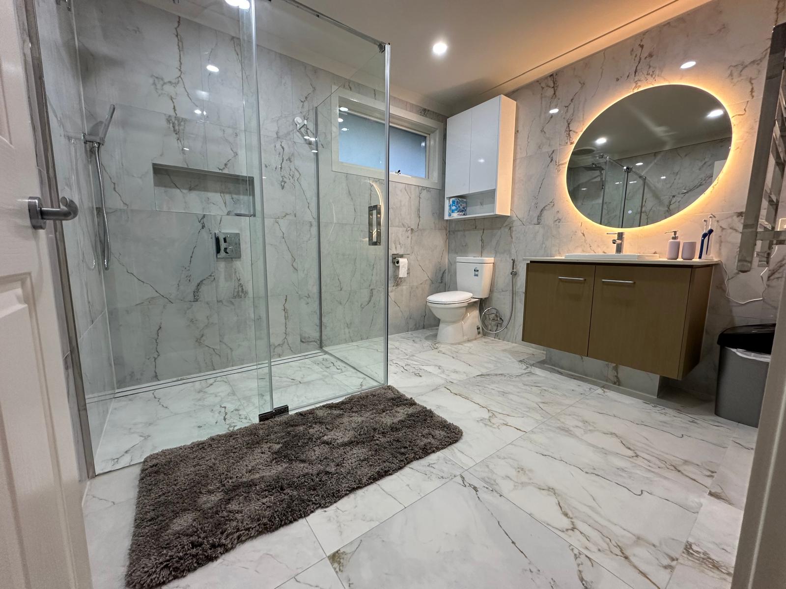 Full bathroom view showcasing marble tiles and modern amenities